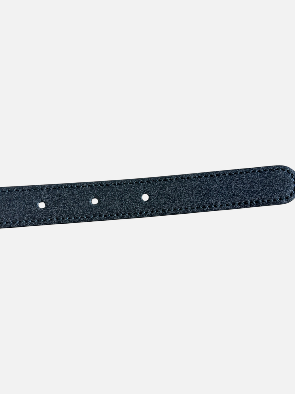 CURATED by Kira black cowhide leather belt strap with detailed stitching on a rustic wooden surface