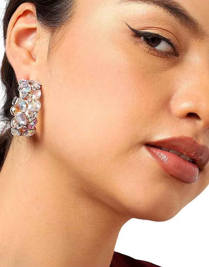CURATED by Kira gold-plated hoop earrings featuring iridescent stones worn by a model with winged eyeliner