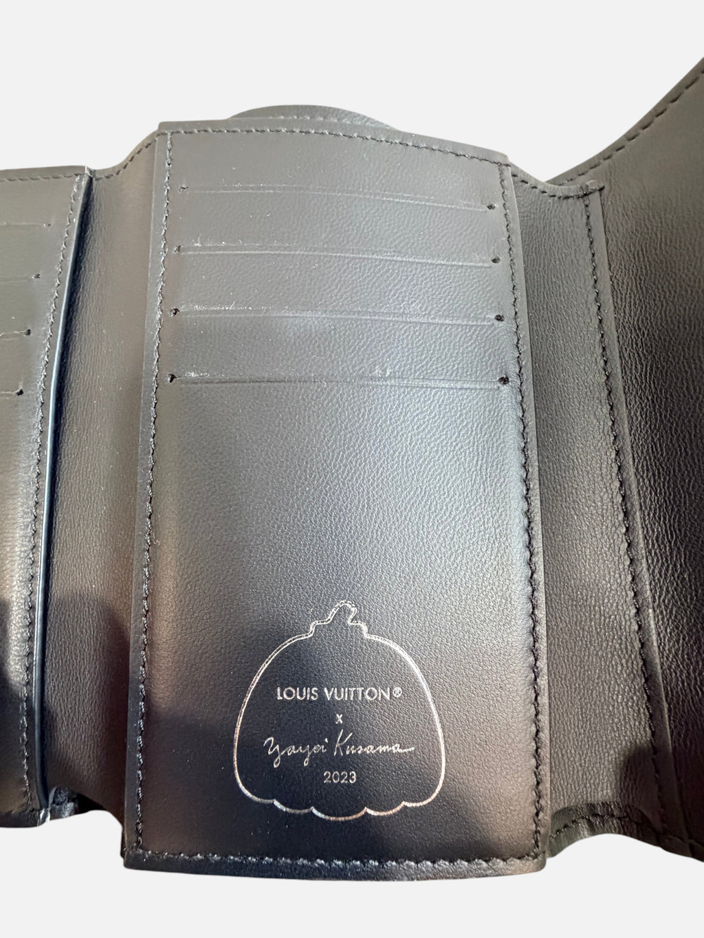 CURATED by Kira Louis Vuitton x Yayoi Kusama Capucines wallet interior with embossed pumpkin logo on black leather