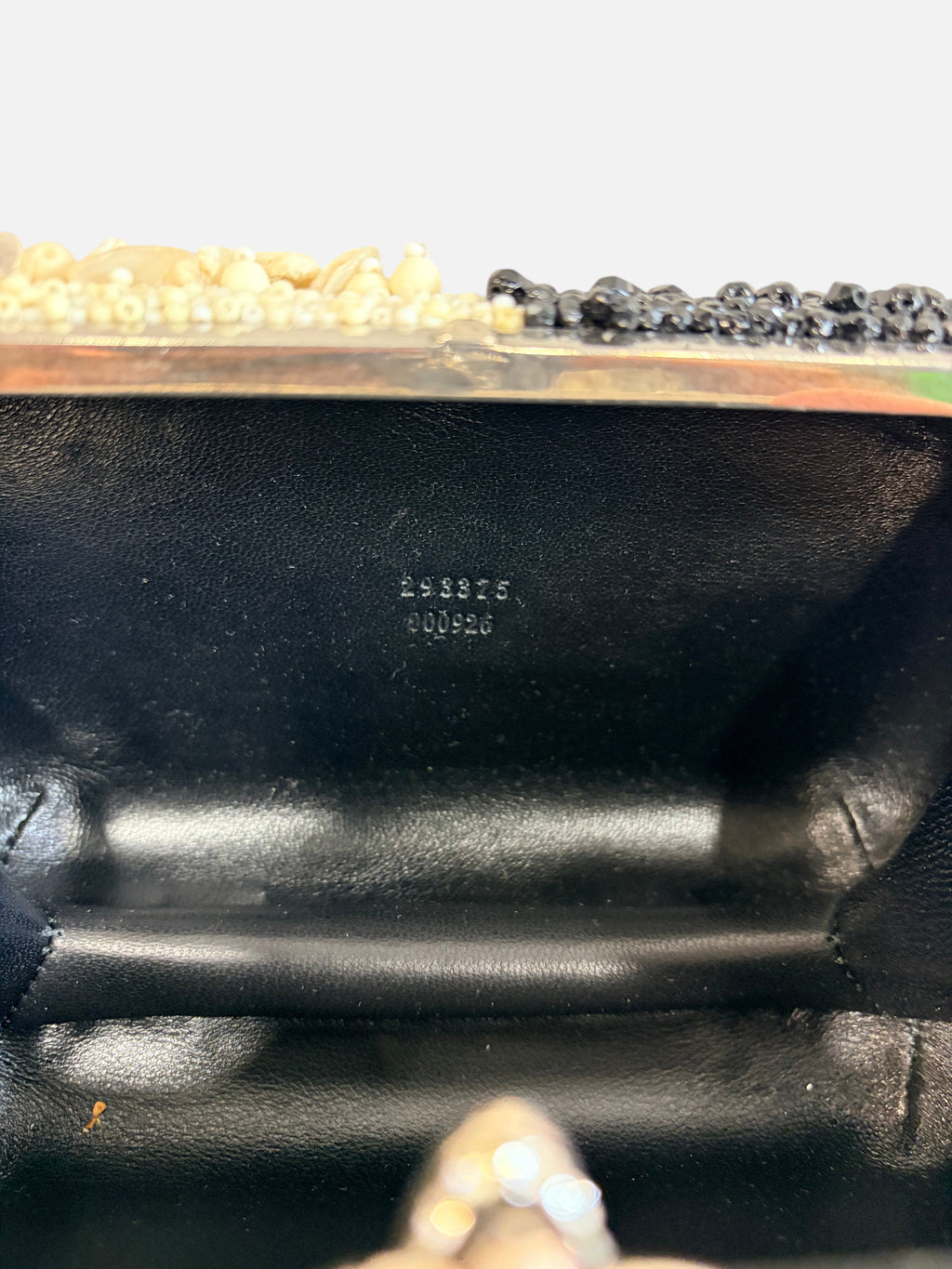 CURATED by Kira Alexander McQueen shell and bead clutch interior showing serial number stamped on black leather lining
