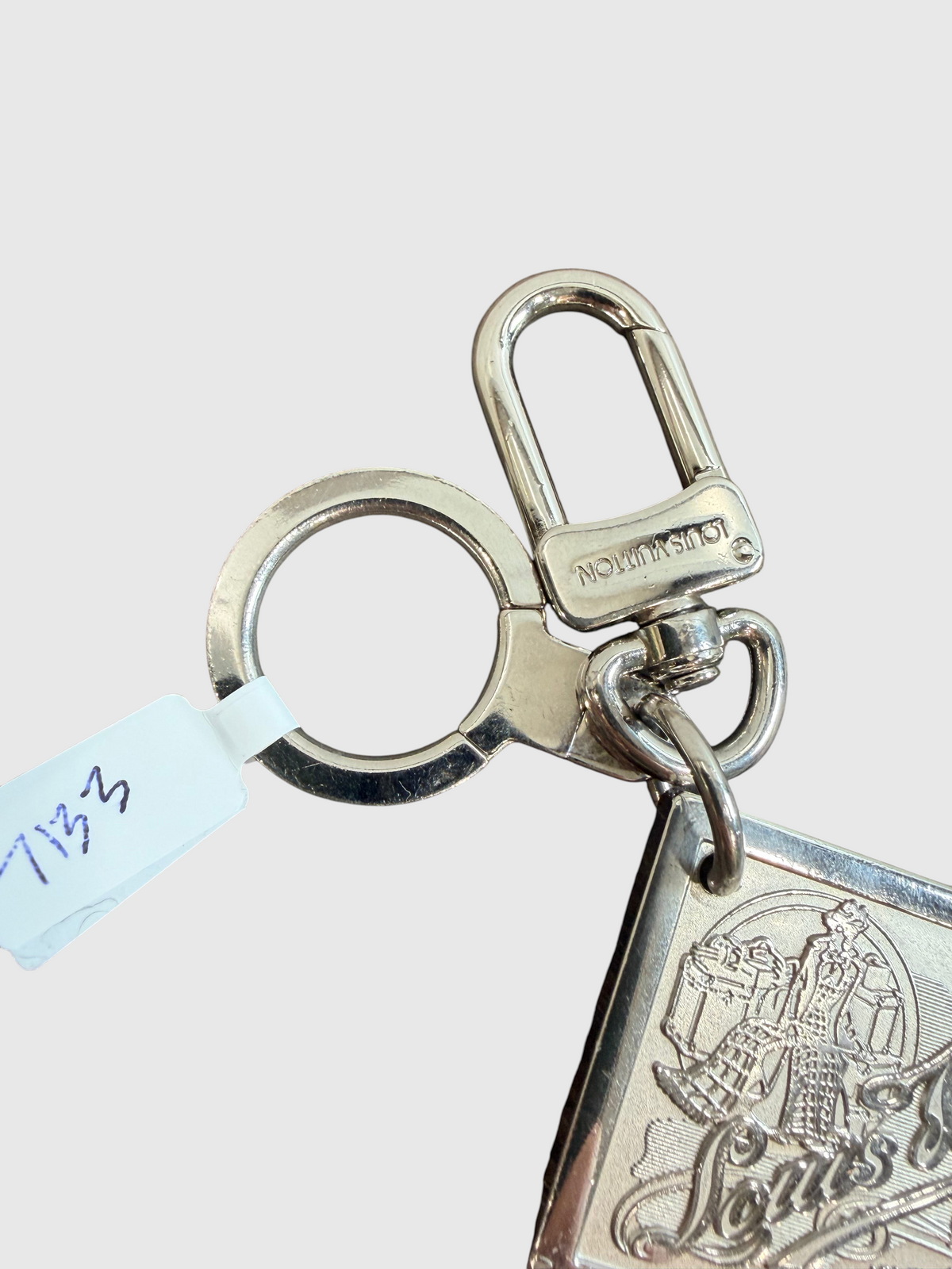 CURATED by Kira Louis Vuitton Traveling Requisites silver metal keychain bag charm with engraved logo detail