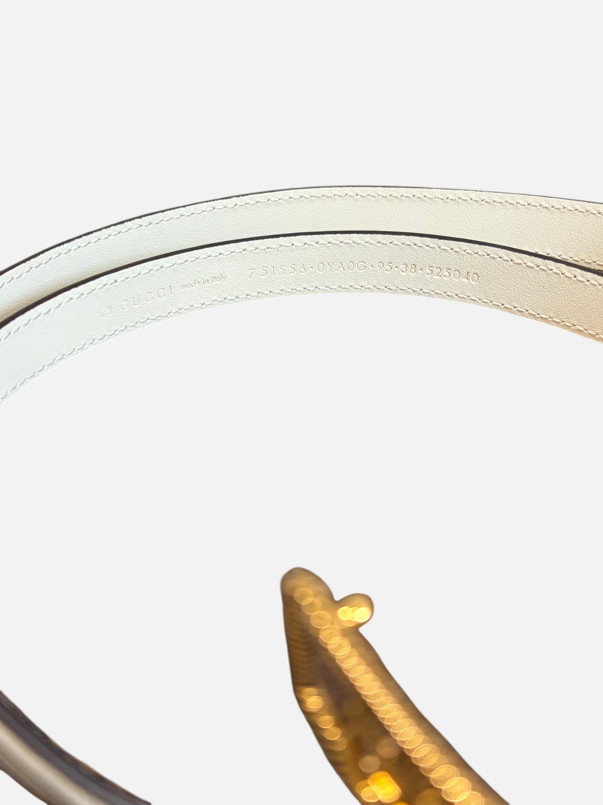 CURATED by Kira Gucci leather belt in Mystic White showing interior branding and serial number on wooden surface