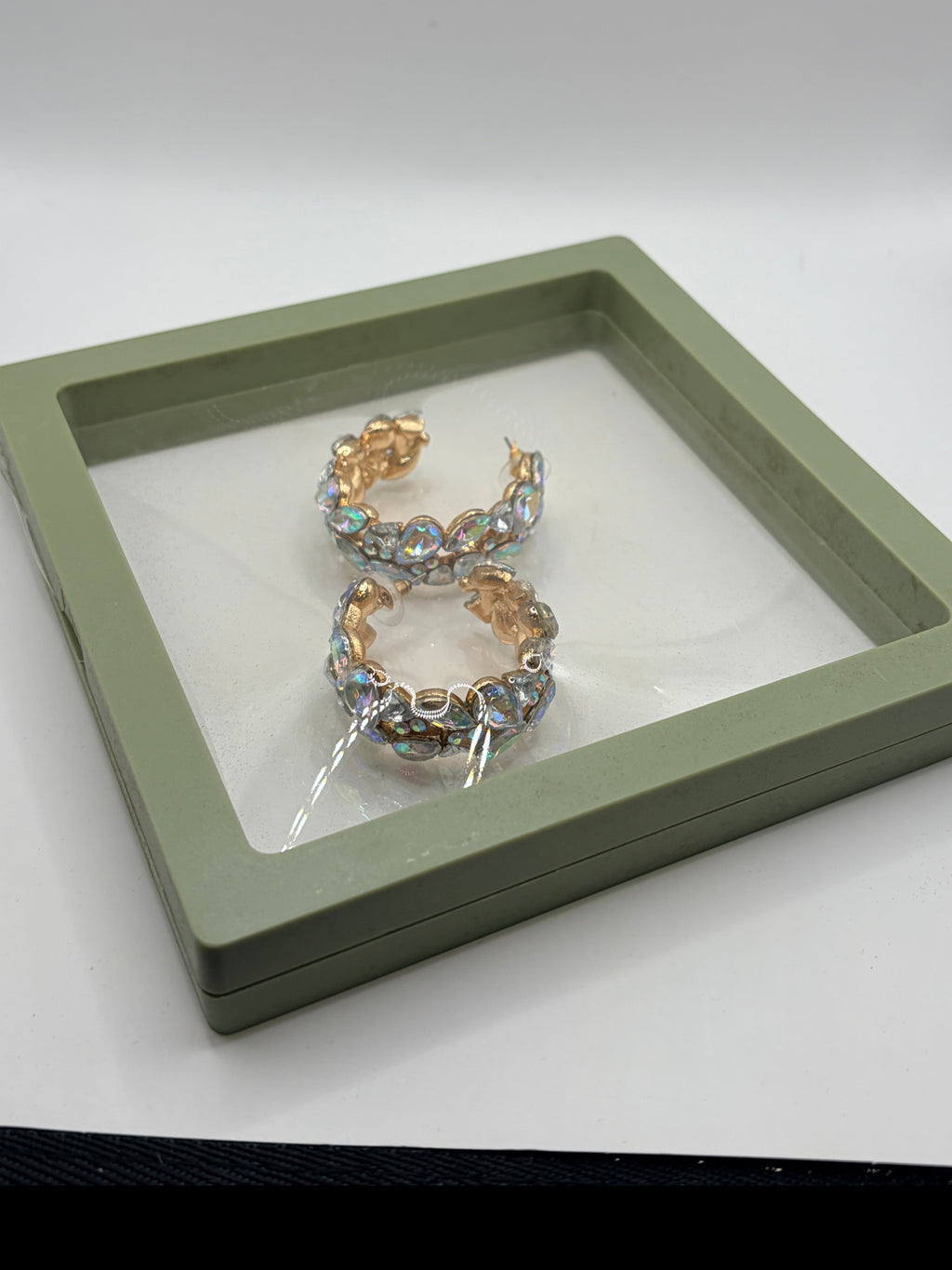 CURATED by Kira gold-plated hoop earrings featuring iridescent stones in a green display box