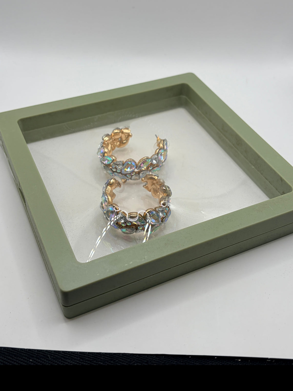 CURATED by Kira gold-plated hoop earrings featuring iridescent stones in a green display box