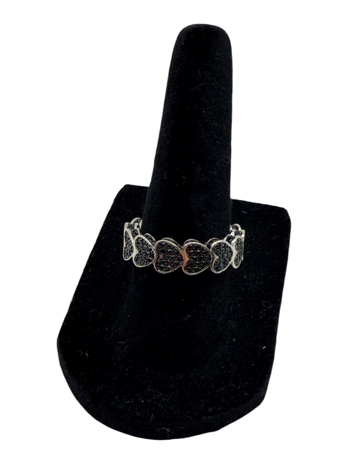 CURATED by Kira black spinel pave heart eternity ring in rhodium plated sterling silver on a black velvet display