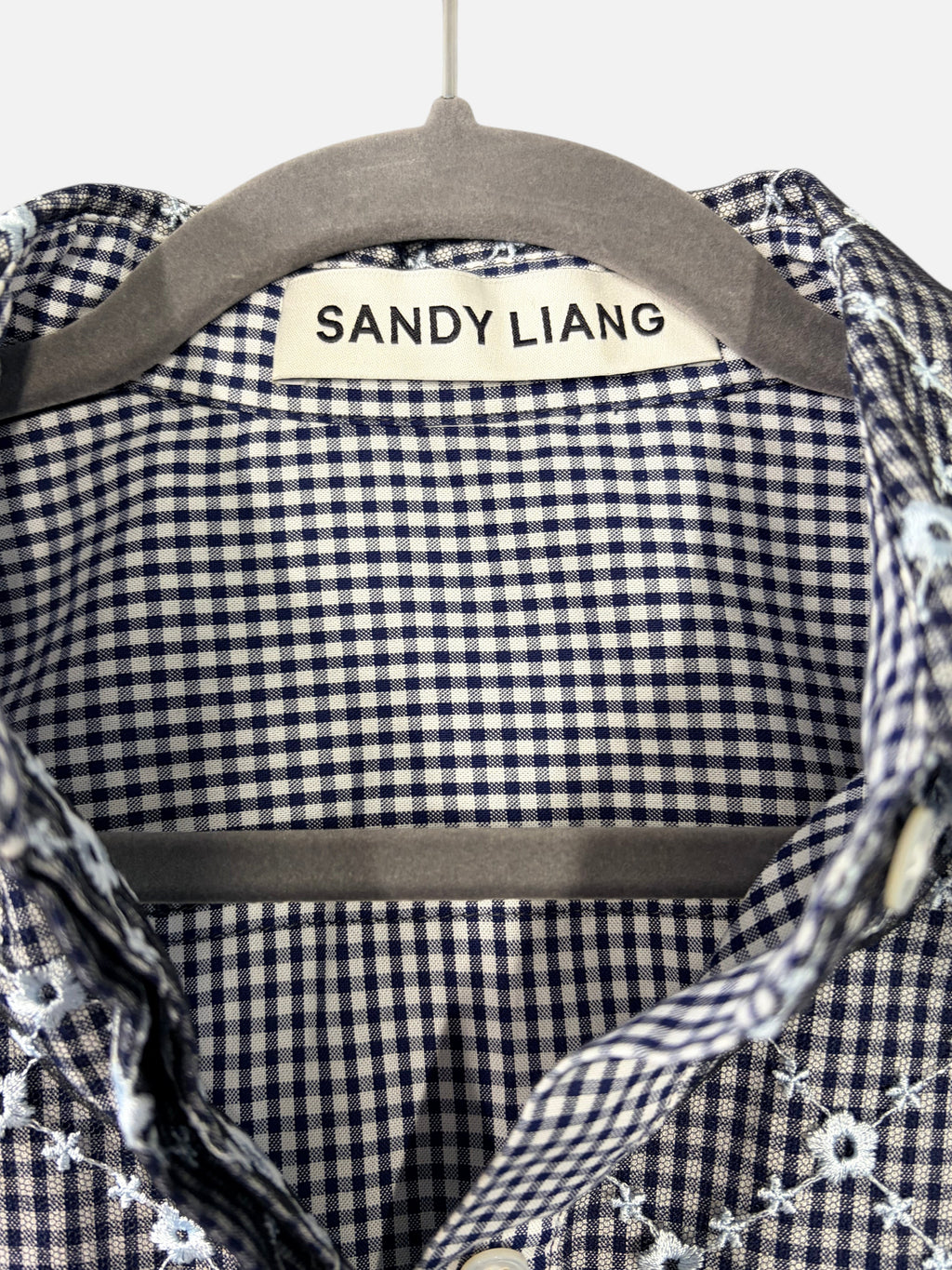 CURATED by Kira Sandy Liang Toney top featuring a navy gingham pattern with delicate floral embroidery on a mesh overlay