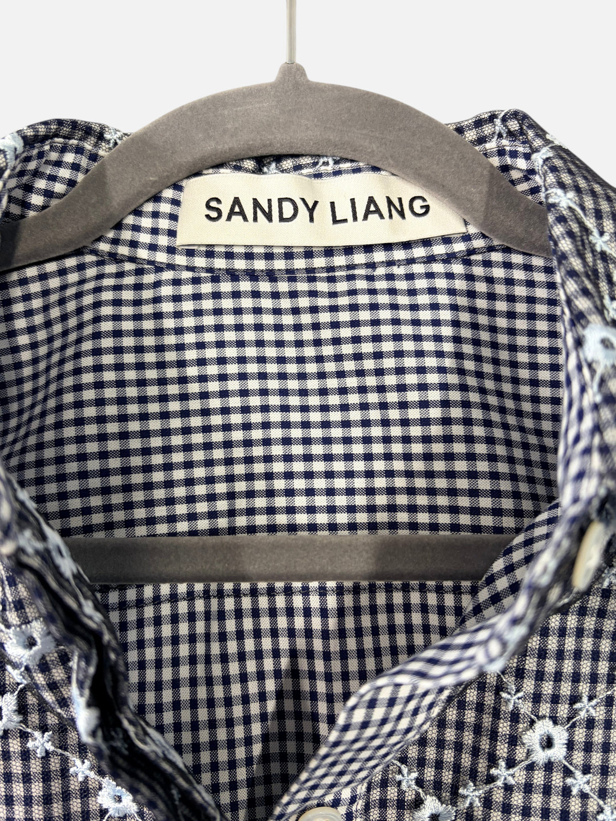 CURATED by Kira Sandy Liang Toney top featuring a navy gingham pattern with delicate floral embroidery on a mesh overlay