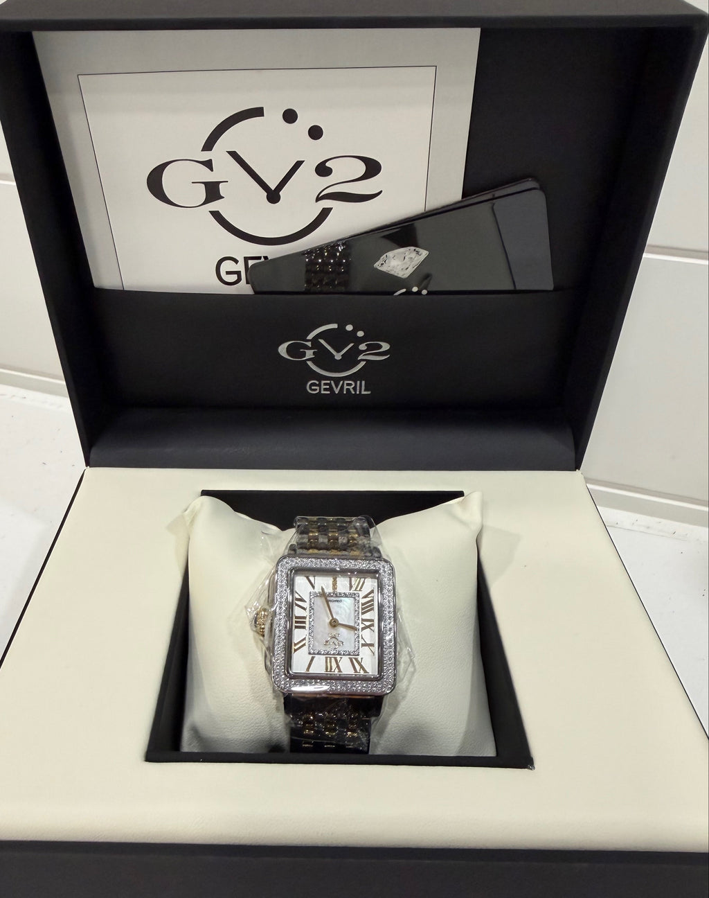 Silver watch in a black and white box with 'GEVRL' branding.