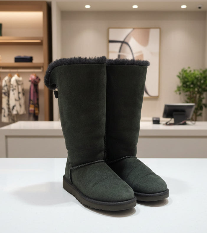 Black boots on a white surface with a clothing store in the background