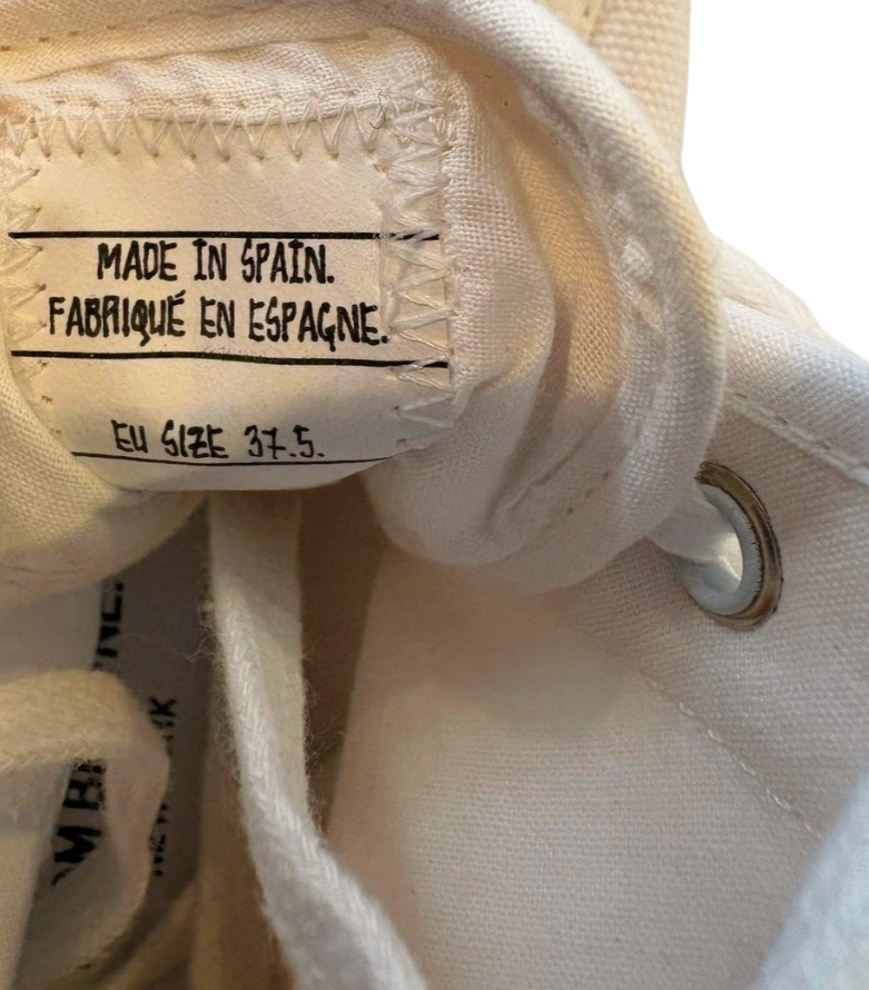 Close-up of a white sneaker with a 'Made in Spain' label.