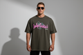 Brown t-shirt with pink text on a hanger against a white background