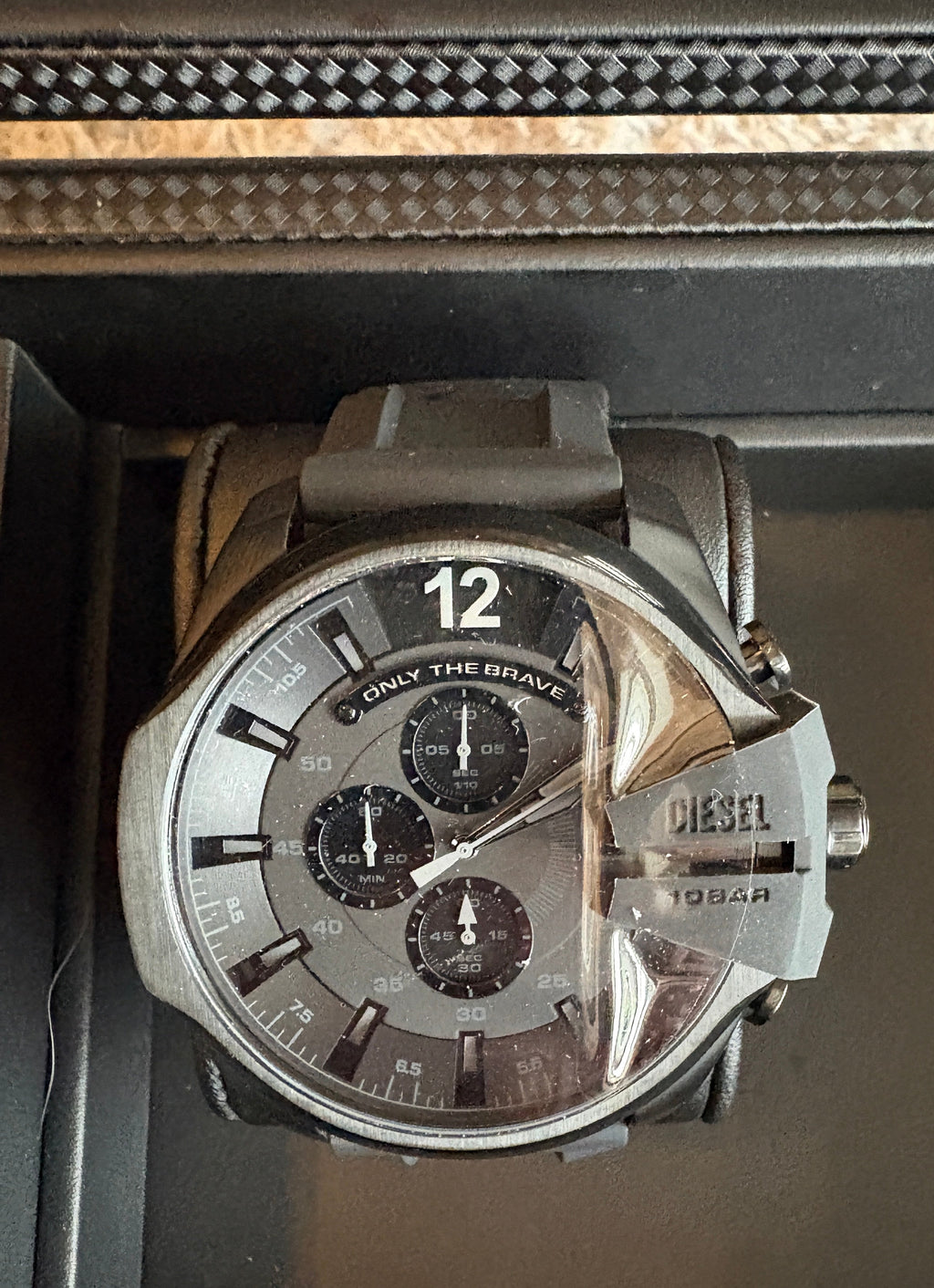Large Diesel watch with a detailed face on a dark surface