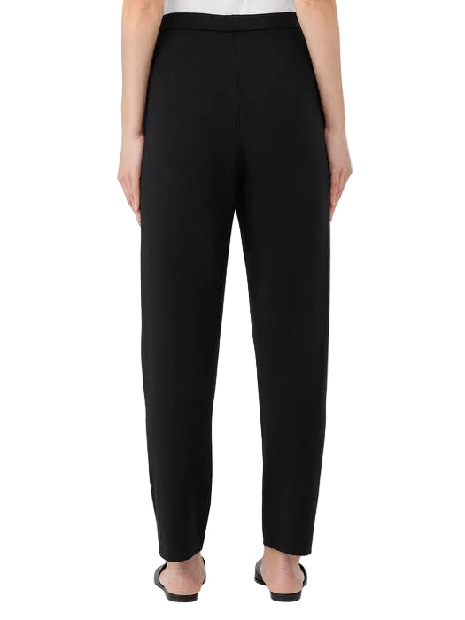 Black pants worn by a person on a white background