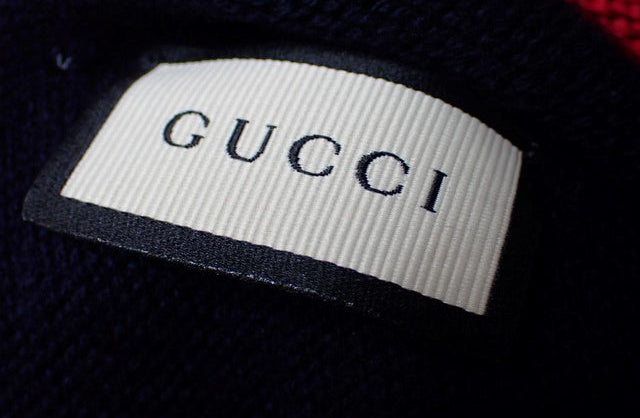 Gucci label on a dark fabric background