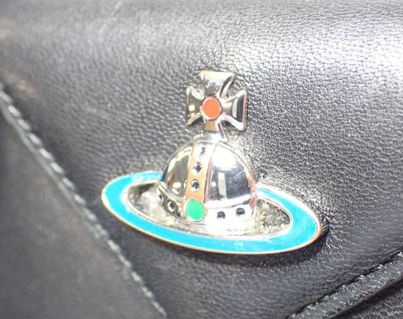 Metallic badge with a cross on a black leather surface