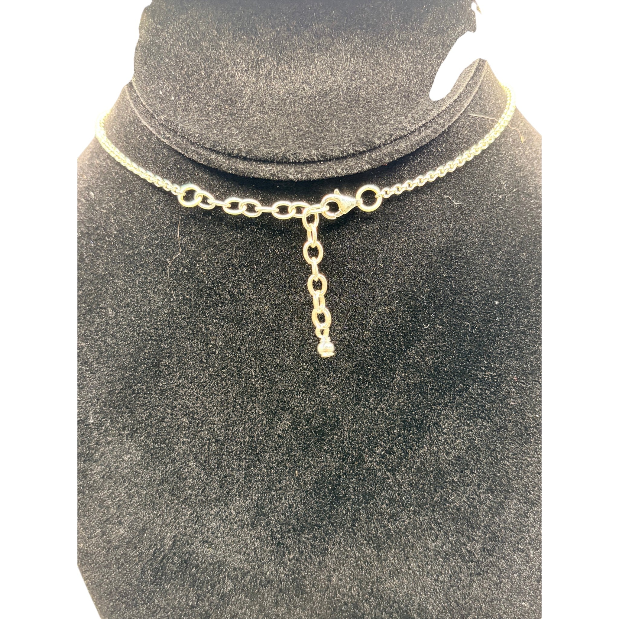 CURATED by Kira Barse sterling silver squash blossom necklace featuring a teal turquoise stone on a black display