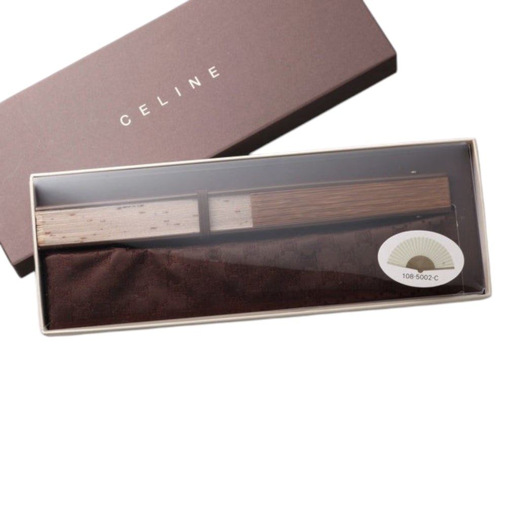 CURATED by Kira Celine beige folding fan with wooden handle, presented in a branded storage box with a fabric pouch.