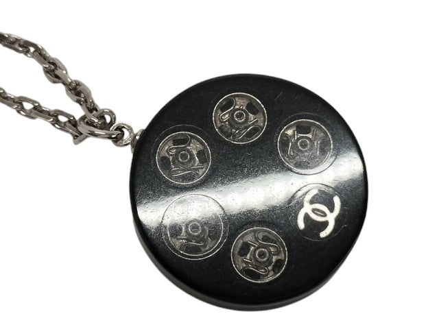 CURATED by Kira Chanel Coco Tire necklace with silver chain and black pendant featuring five circular details and a CC logo.