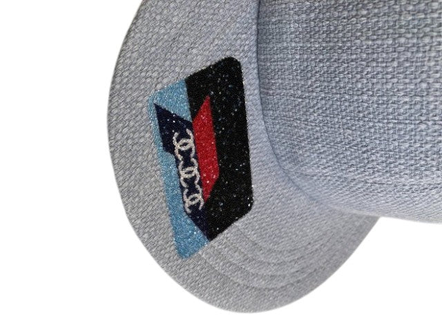 CURATED by Kira Chanel denim hat featuring a glittery logo patch with blue, black, and red accents.