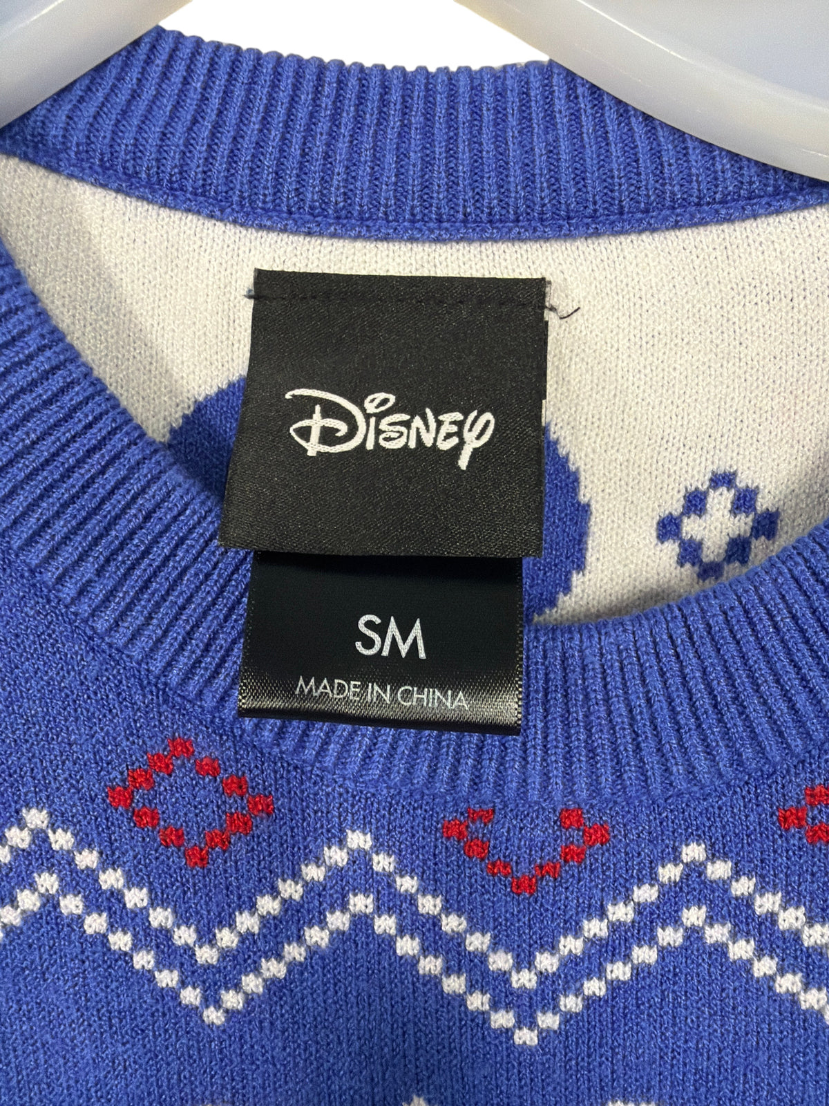 CURATED by Kira Disney Parks Big Hero 6 holiday sweater size small tag detail with blue and white knit pattern