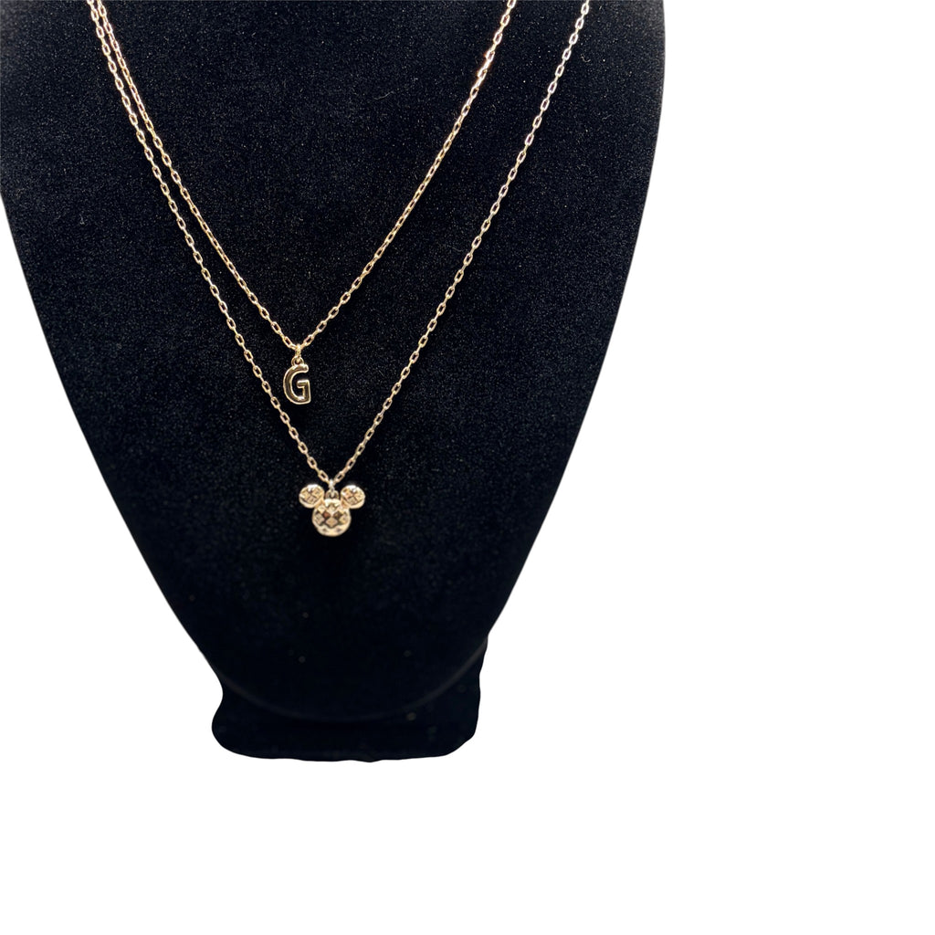 CURATED by Kira Disney Mickey Mouse gold initial pendant necklace with cubic zirconia accents on a black display bust
