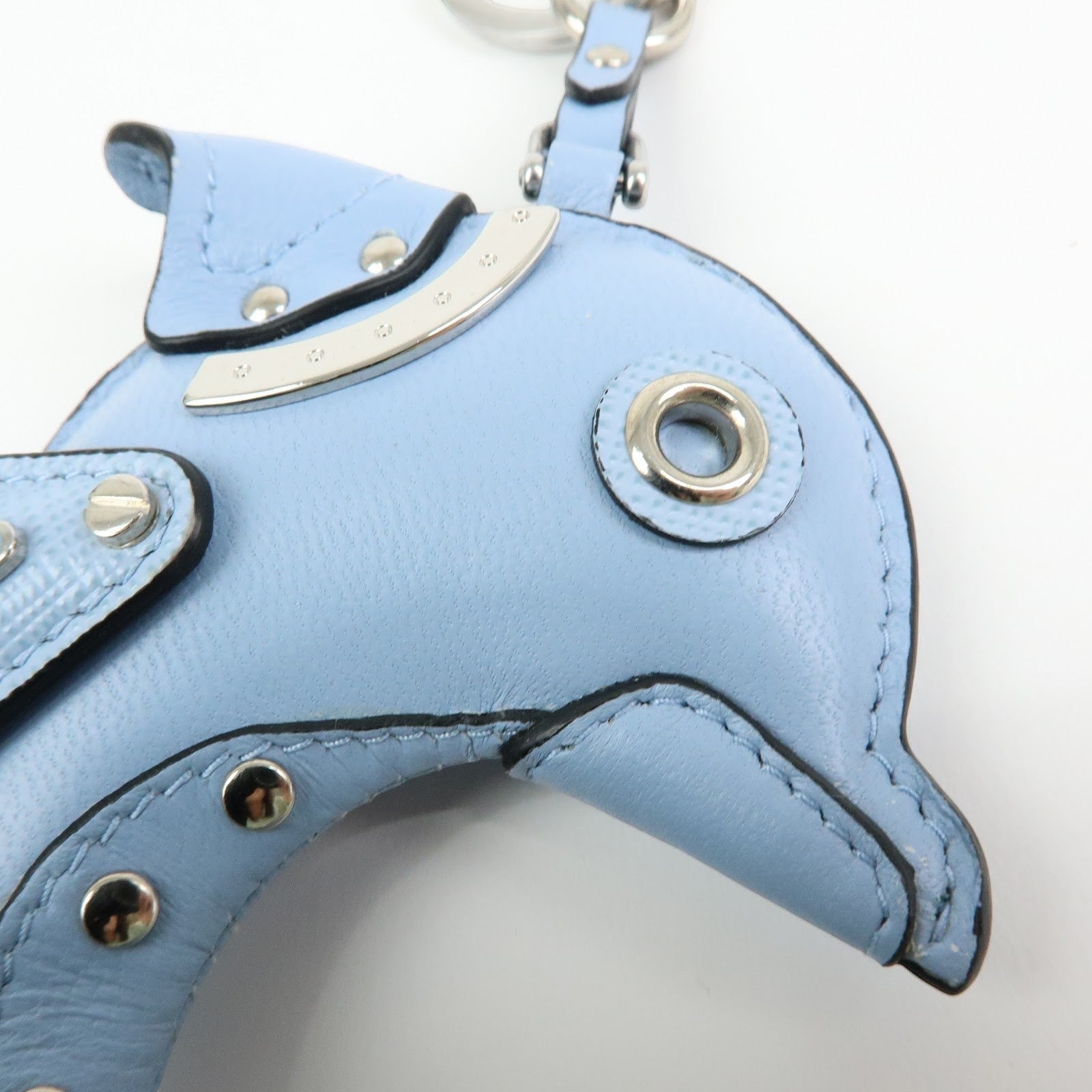 CURATED by Kira light blue Saffiano leather dolphin charm with silver hardware and triangle logo detail.