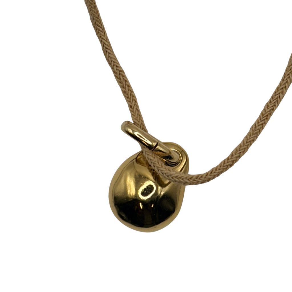 CURATED by Kira Uno de 50 gold tone ball charm on a beige cord necklace