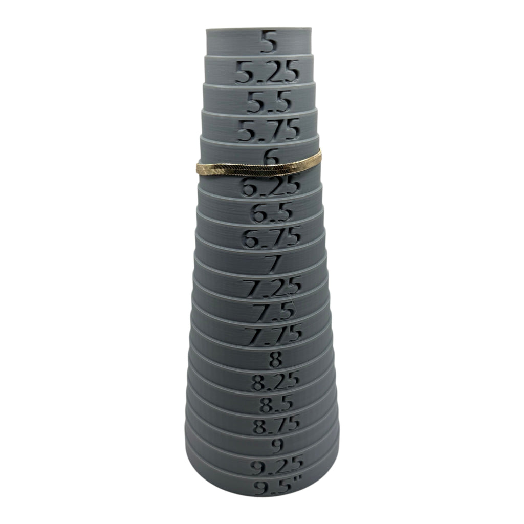 CURATED by Kira gold tone Kate Spade herringbone chain bracelet resting on a grey plastic ring sizer at size 6