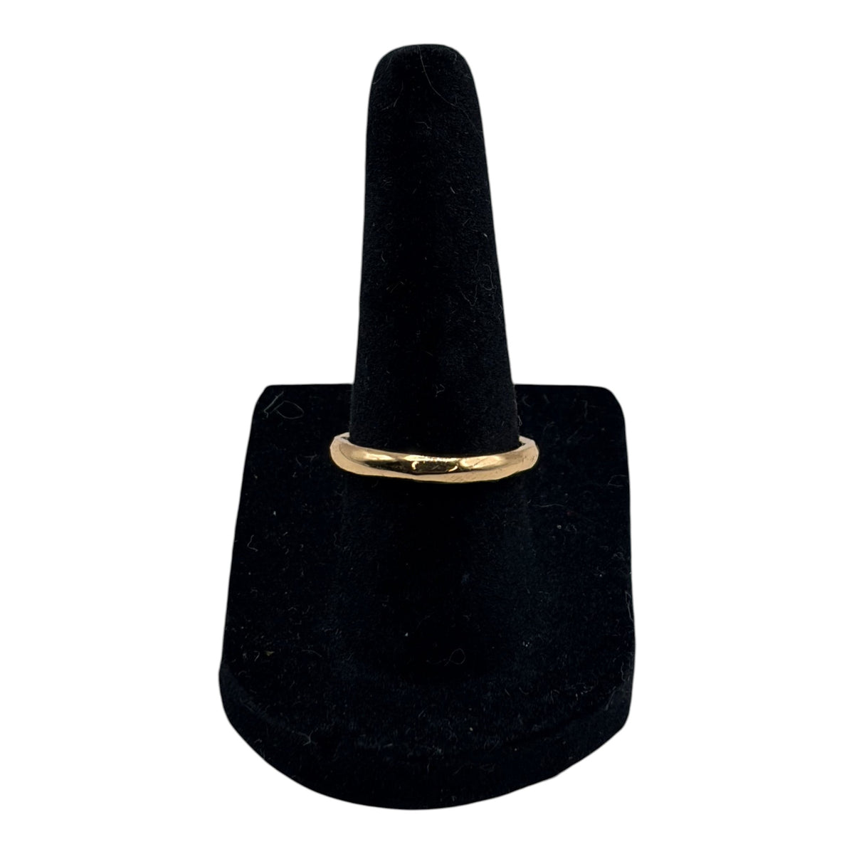 CURATED by Kira gold tone simple band ring displayed on a black velvet ring stand