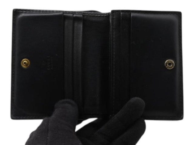 CURATED by Kira black Gucci Guccissima bi-fold wallet with interior card slots and gold-tone snap button closure