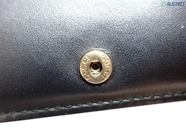 CURATED by Kira Gucci Guccissima black leather bi-fold wallet featuring a gold-tone snap button with Gucci branding