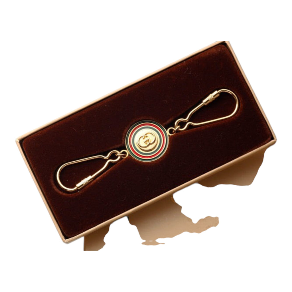 CURATED by Kira Gucci Interlocking G keyring in gold with signature red and green enamel detail in a display box.