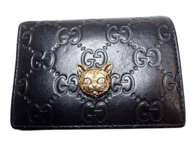 CURATED by Kira black Gucci Guccissima bi-fold leather wallet featuring a gold-tone metal cat head emblem.