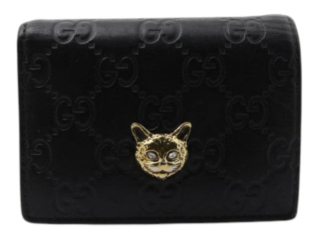 CURATED by Kira black Gucci Guccissima leather bi-fold wallet featuring a gold-tone metal cat head emblem.