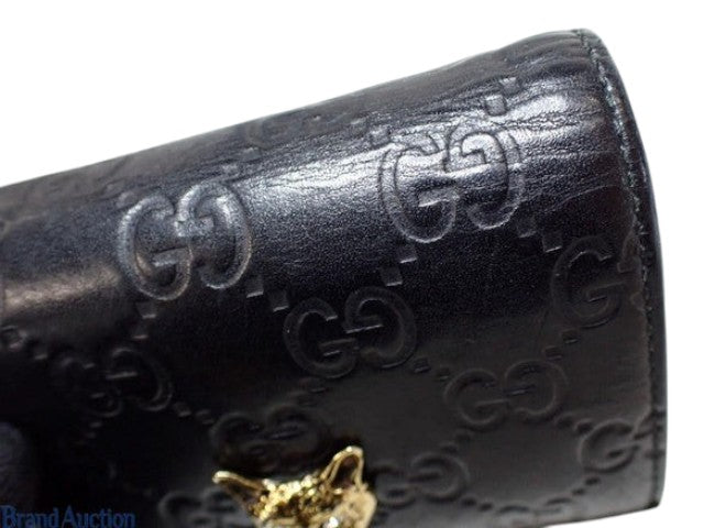CURATED by Kira black Gucci Guccissima leather bi-fold wallet featuring an embossed GG pattern and gold cat head