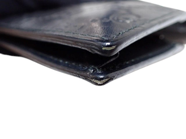 CURATED by Kira black Gucci Guccissima bi-fold wallet edge detail showing leather texture and stitching