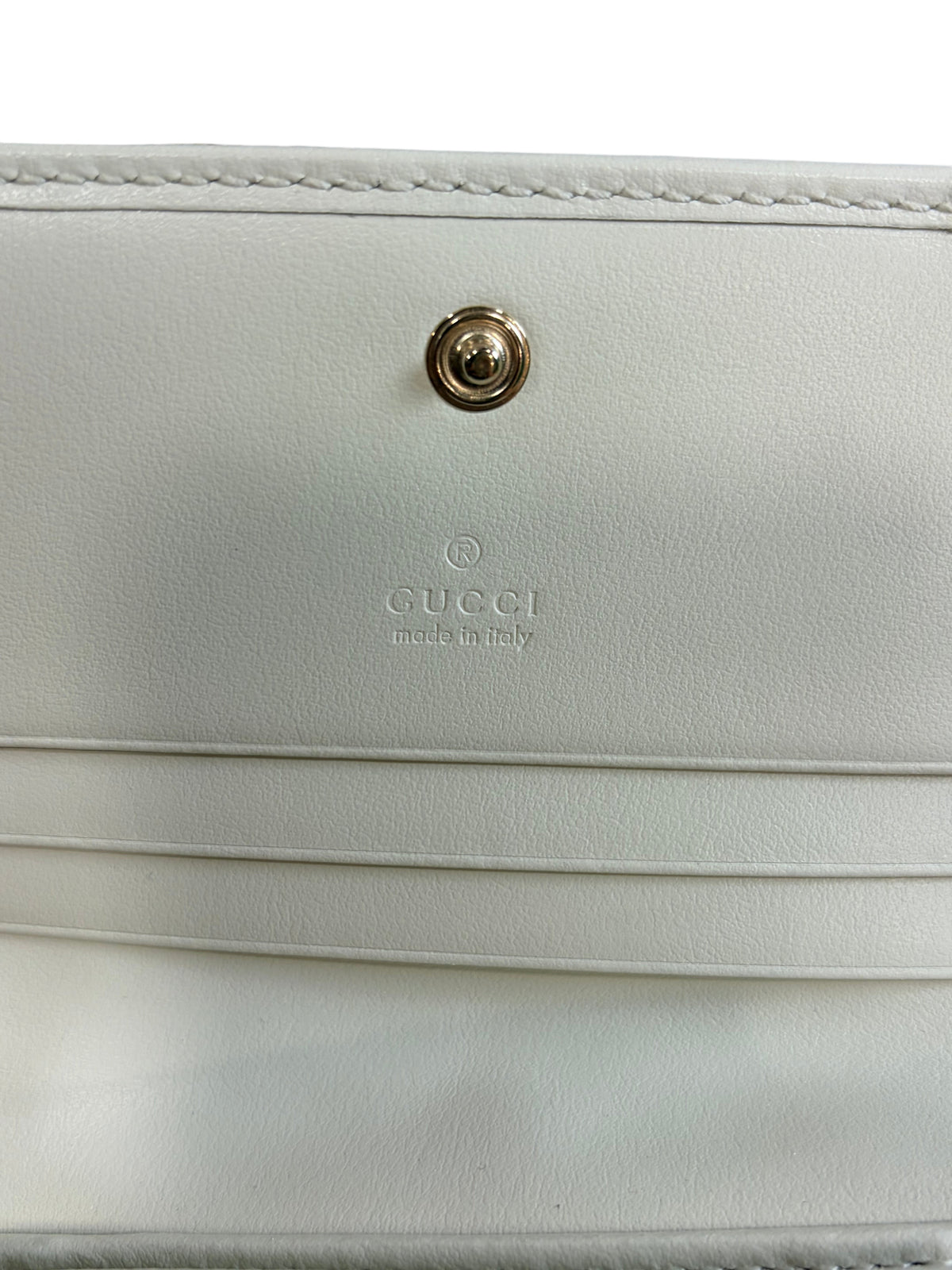 CURATED by Kira Gucci GG Marmont wallet interior featuring white leather, card slots, and debossed logo branding