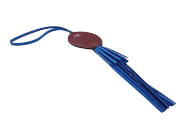 CURATED by Kira Hermes Purupu octopus charm featuring a blue leather tassel and a burgundy leather oval tab