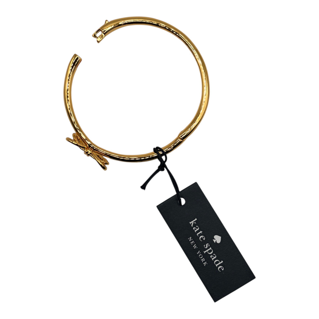 CURATED by Kira gold tone Kate Spade New York hinged bangle bracelet featuring a delicate bow knot detail.