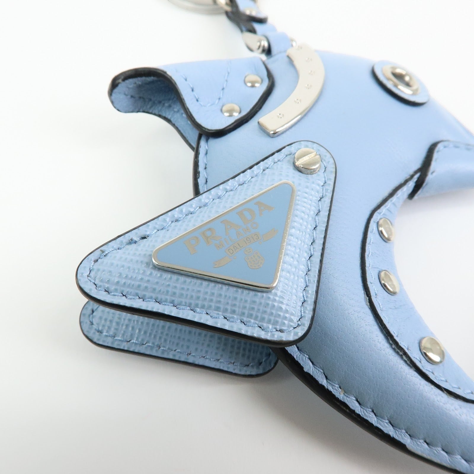 CURATED by Kira light blue Saffiano leather dolphin charm with Prada triangle logo detail and silver-tone hardware.