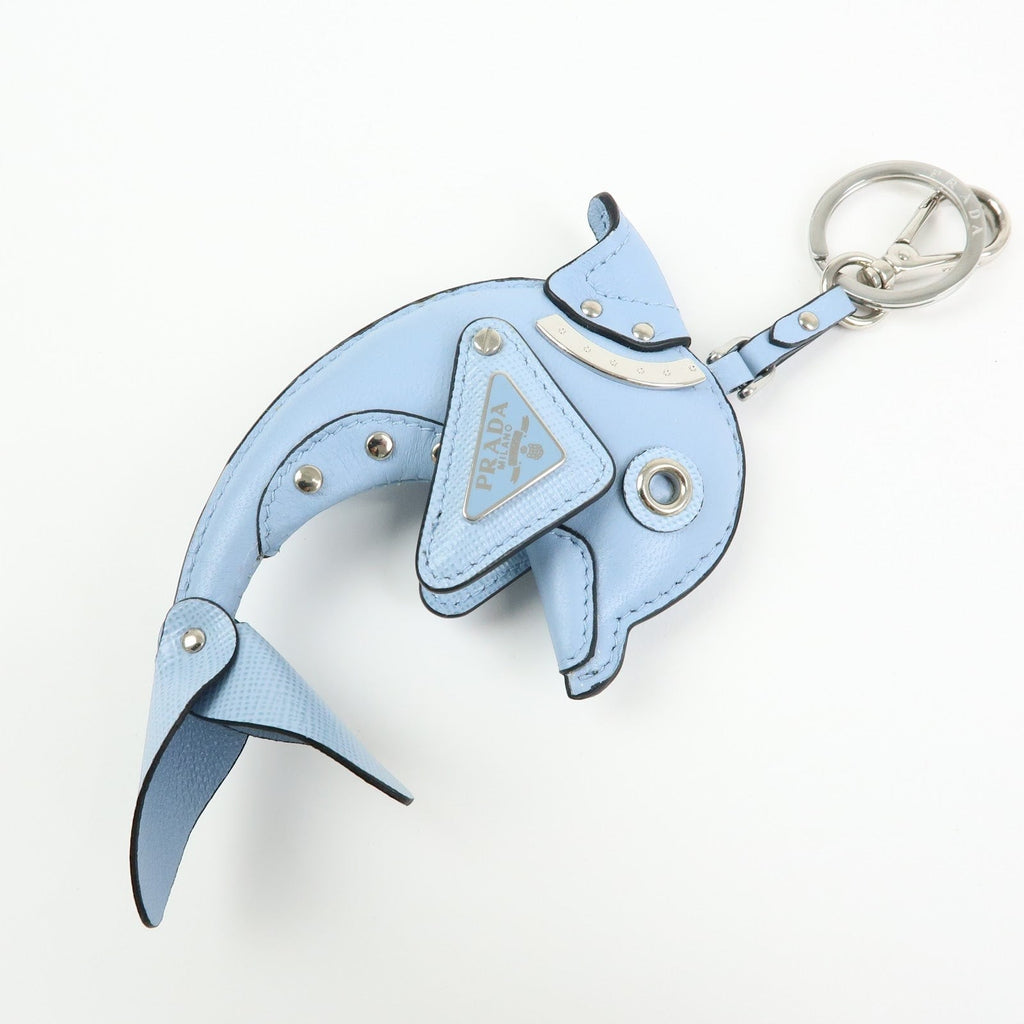CURATED by Kira light blue Saffiano leather dolphin charm keychain with Prada triangle logo detail and silver-tone hardware.