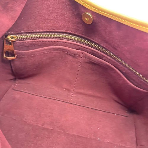Interior of CURATED by Kira Louis Vuitton Carryall PM bag featuring burgundy fabric lining and a gold zipper pocket.