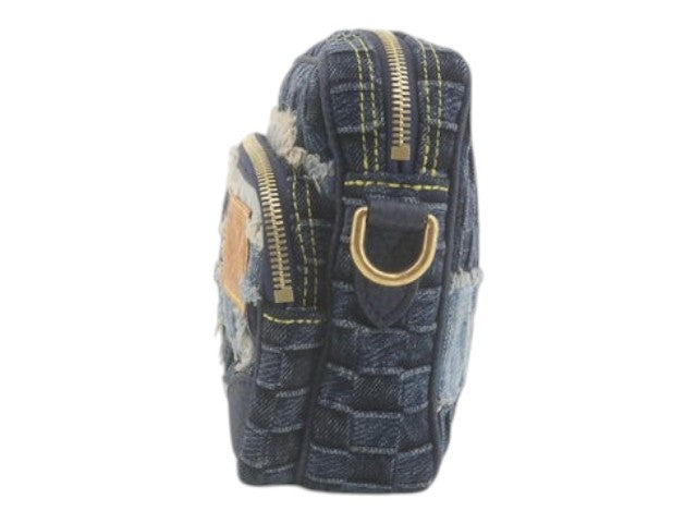 Side view of CURATED by Kira Louis Vuitton Nigo Monogram denim bag in blue with gold hardware and frayed details.