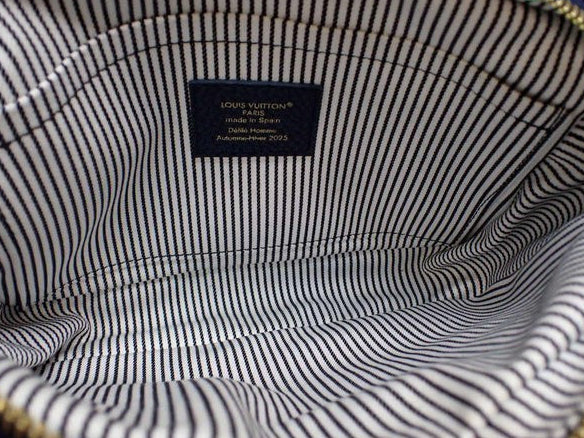 Interior of CURATED by Kira Louis Vuitton Nigo Monogram Denim bag featuring blue and white striped fabric lining