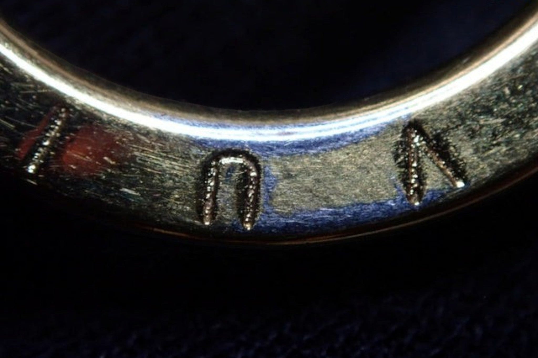 CURATED by Kira Louis Vuitton M63086 gold charm featuring engraved logo detail in a close-up view