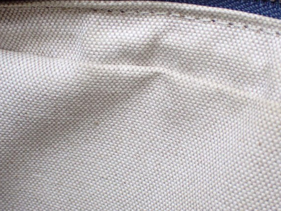 Interior lining of a CURATED by Kira Louis Vuitton Nile NM bag featuring durable beige canvas fabric