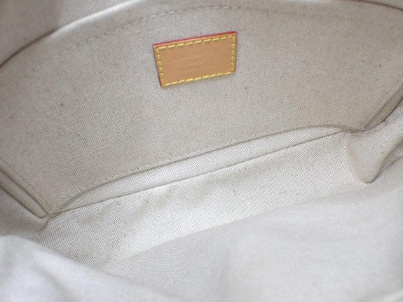 Interior of CURATED by Kira Louis Vuitton Nile NM bag featuring a beige canvas lining and leather brand tag