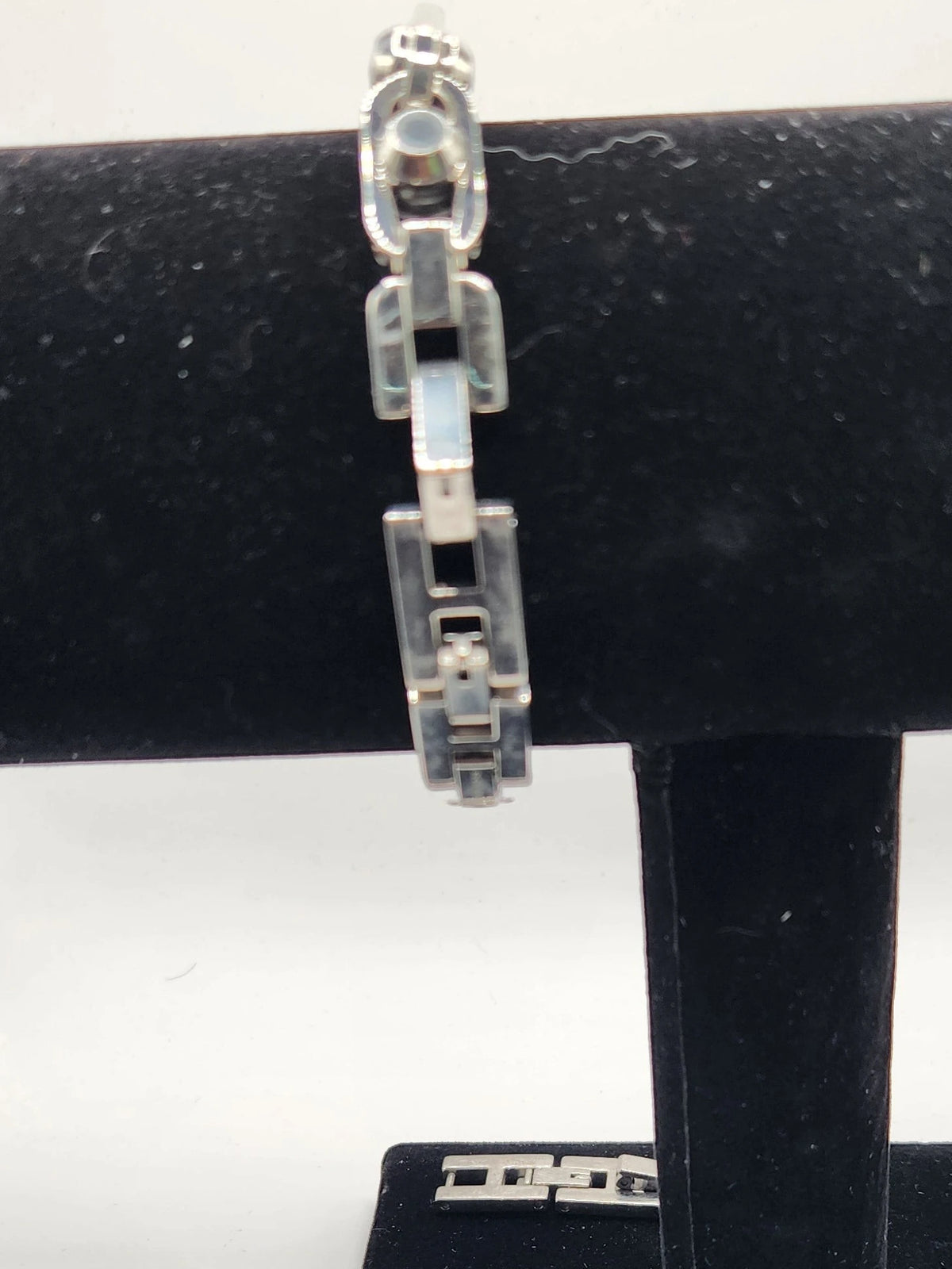 CURATED by Kira Michael Kors Astor silver stainless steel chain-link bracelet watch on a black display stand