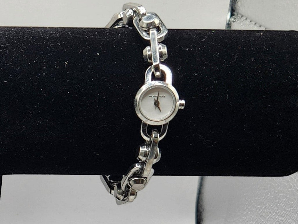 CURATED by Kira Michael Kors Astor silver stainless steel chain-link bracelet watch with white dial on display stand