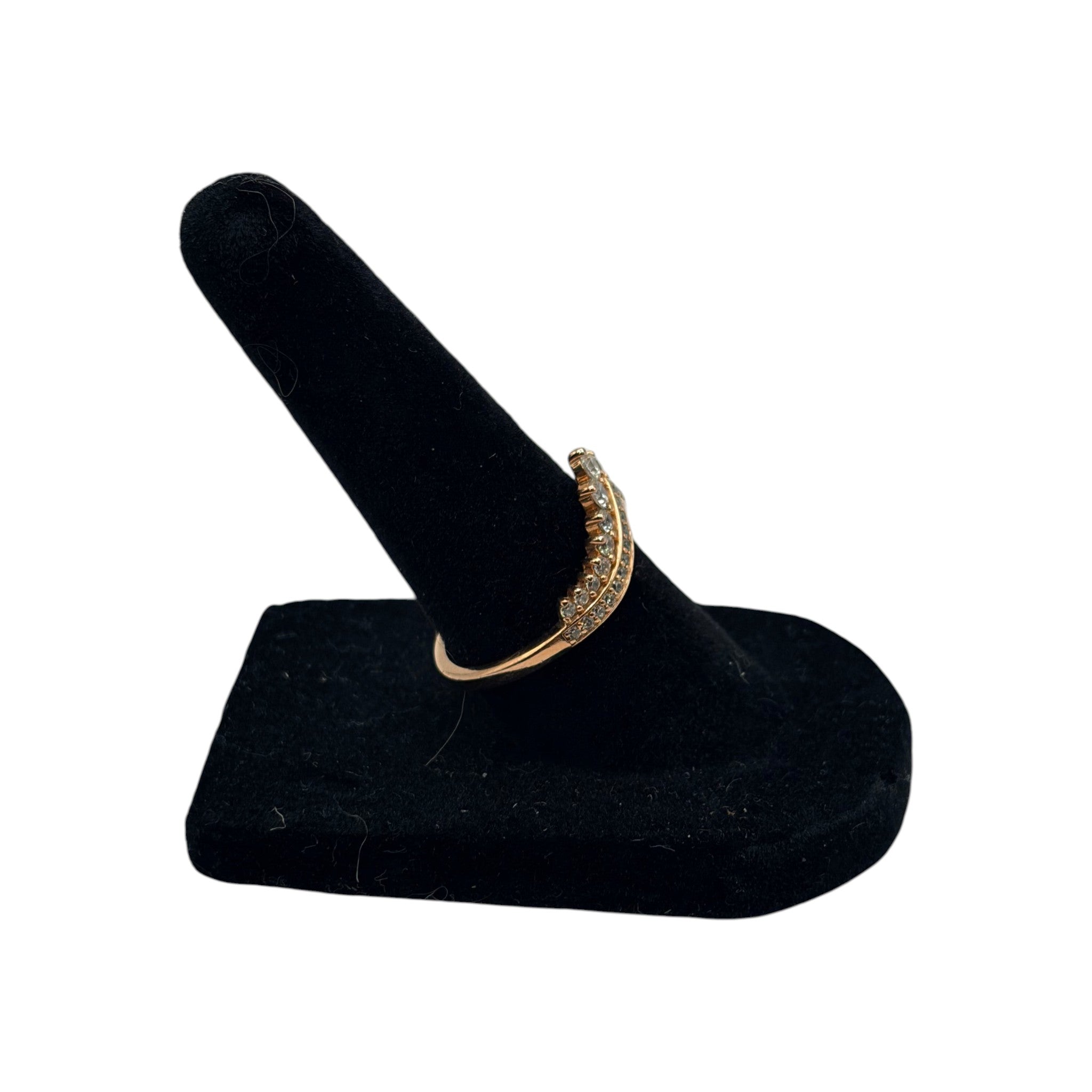 CURATED by Kira Pandora Princess Wishbone ring in 14k rose gold plating with sparkling pavé stones on a black stand.